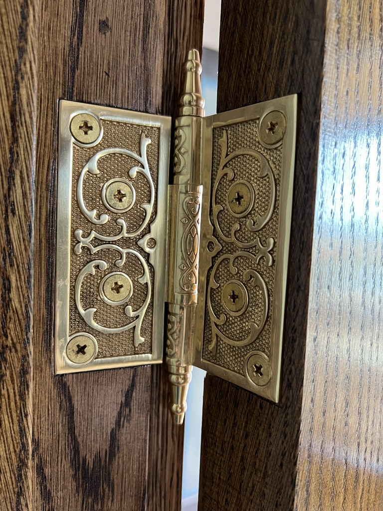 Detailed brass hinge installed on custom woodwork